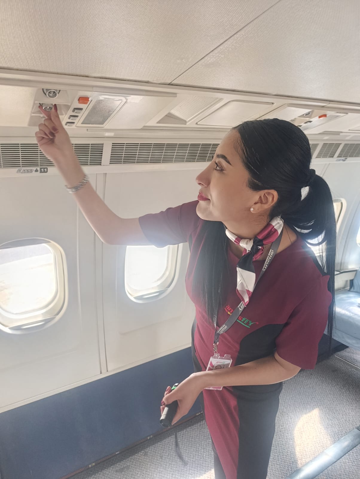 Instructora de AMASFLY señalando equipamiento en la cabina de un avión durante una capacitación